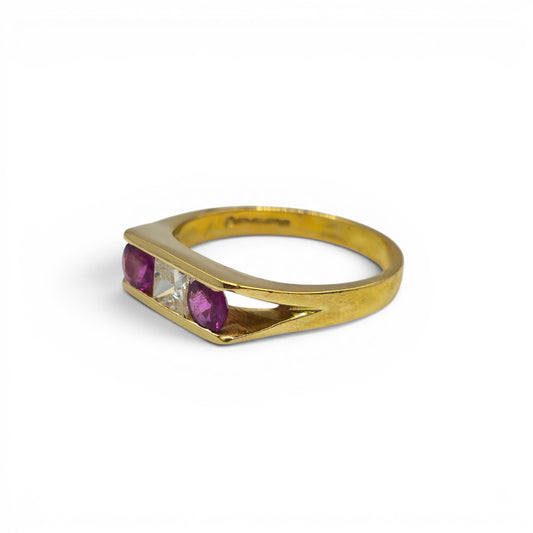 18ct yellow gold ruby and diamond ring by Reeves and Sons, showcasing a sparkling gemstone and intricate band design.