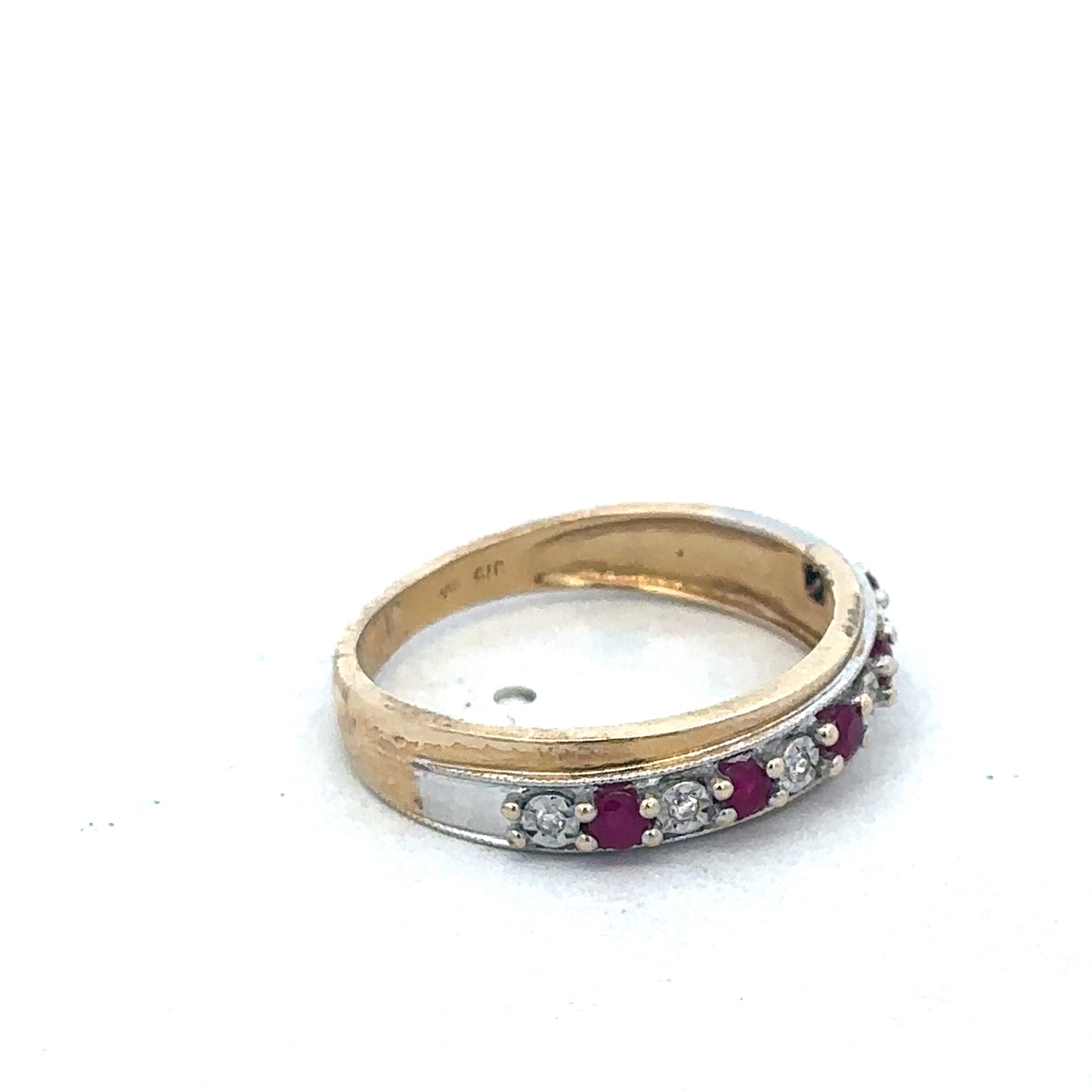 9ct yellow gold ruby and diamond ring by Reeves and Sons, featuring a central ruby surrounded by sparkling diamonds.