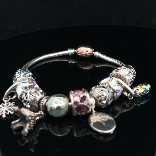 925 silver Chamilia charm bracelet with intricate charms and detailed silver links, showcasing elegant jewelry craftsmanship.