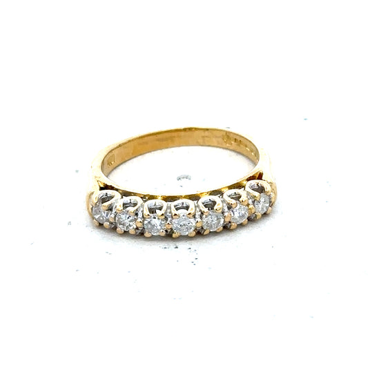 18ct yellow gold half eternity diamond ring with sparkling diamonds encircling the band, showcasing elegant jewelry design.