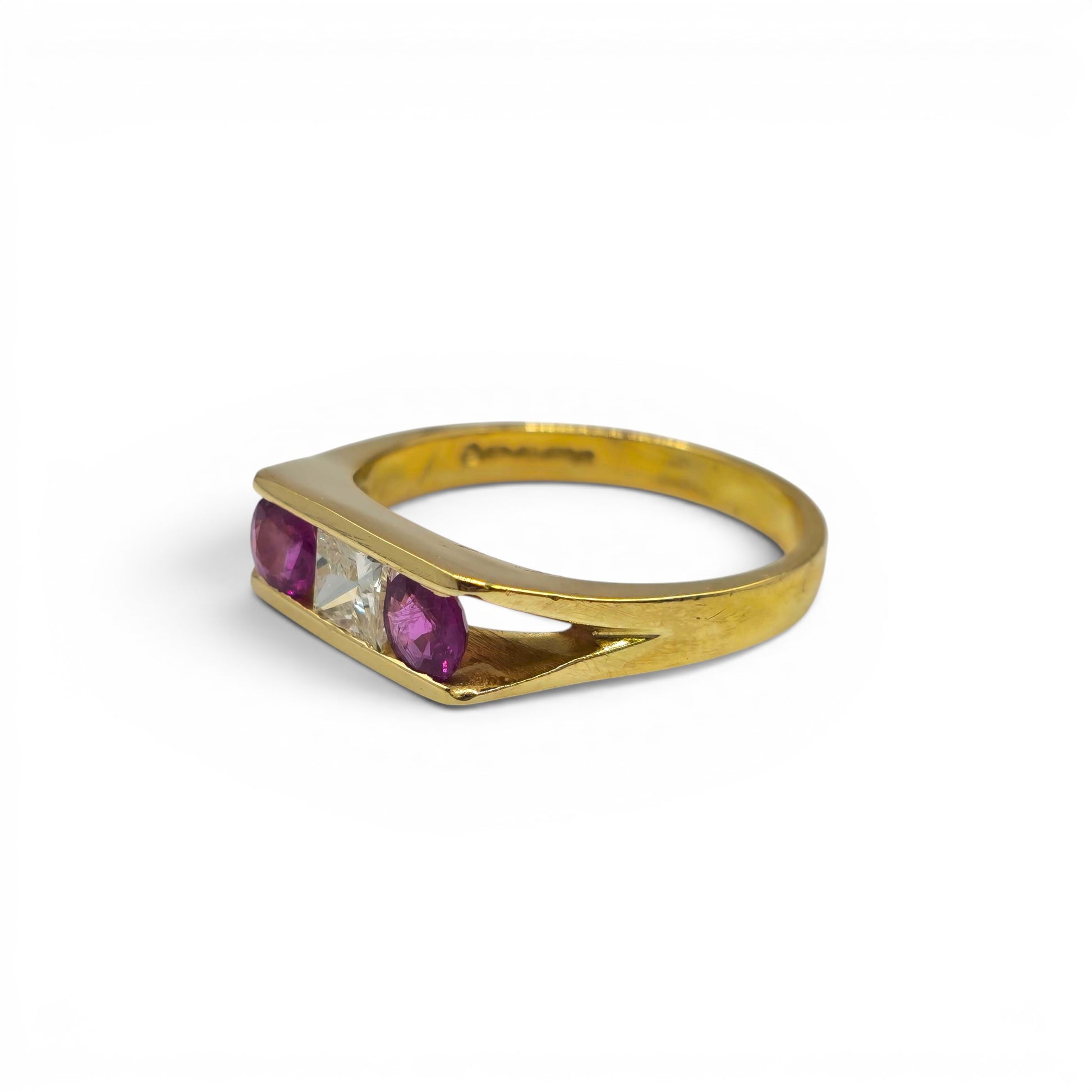 18ct yellow gold ruby and diamond ring by Reeves and Sons, showcasing a sparkling gemstone and intricate band design.