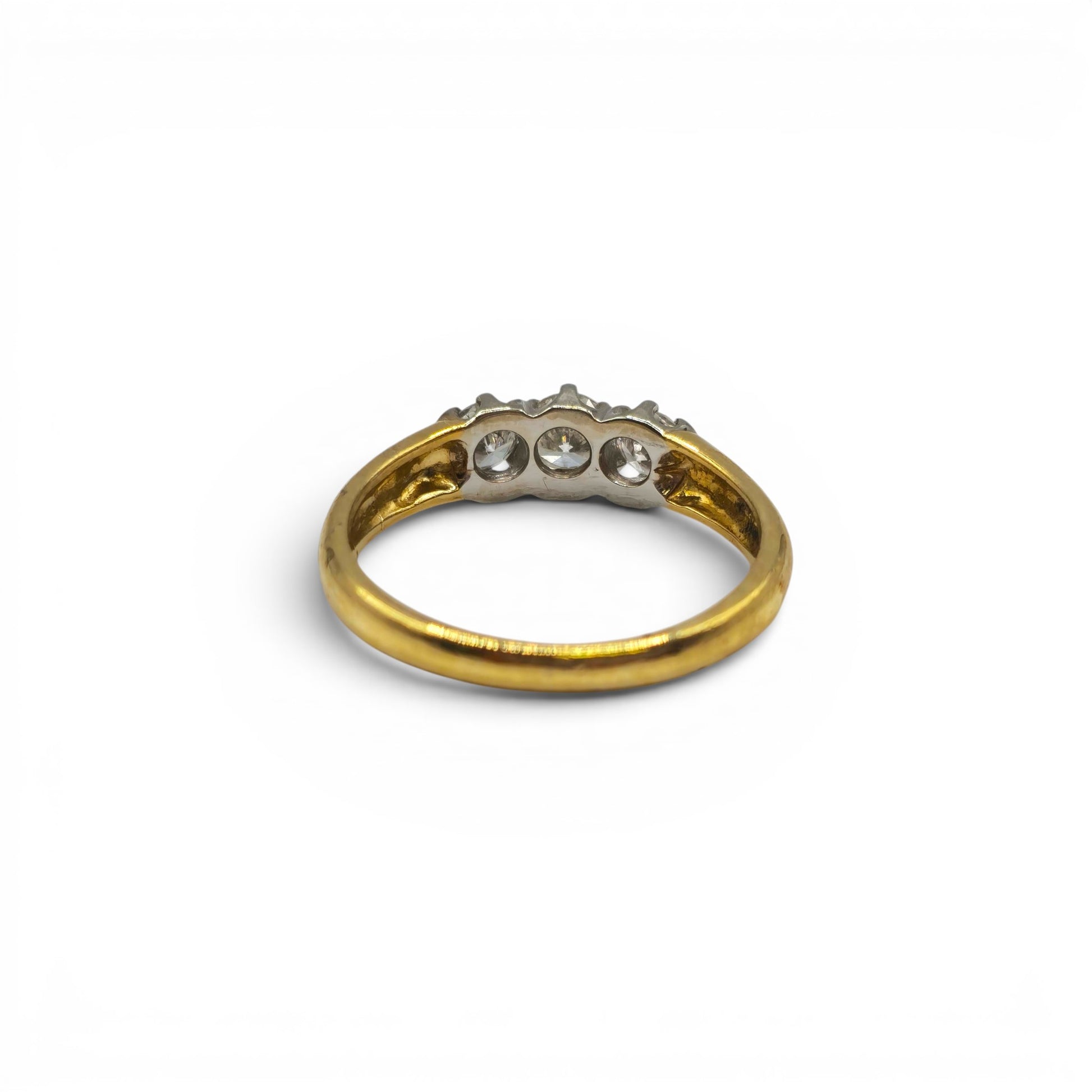 18ct yellow gold three stone diamond ring by Reeves and Sons, featuring a polished gold band with three sparkling diamonds.