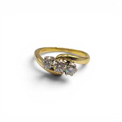18ct yellow gold diamond twist ring by Reeves and Sons, featuring a delicate band with sparkling diamonds.