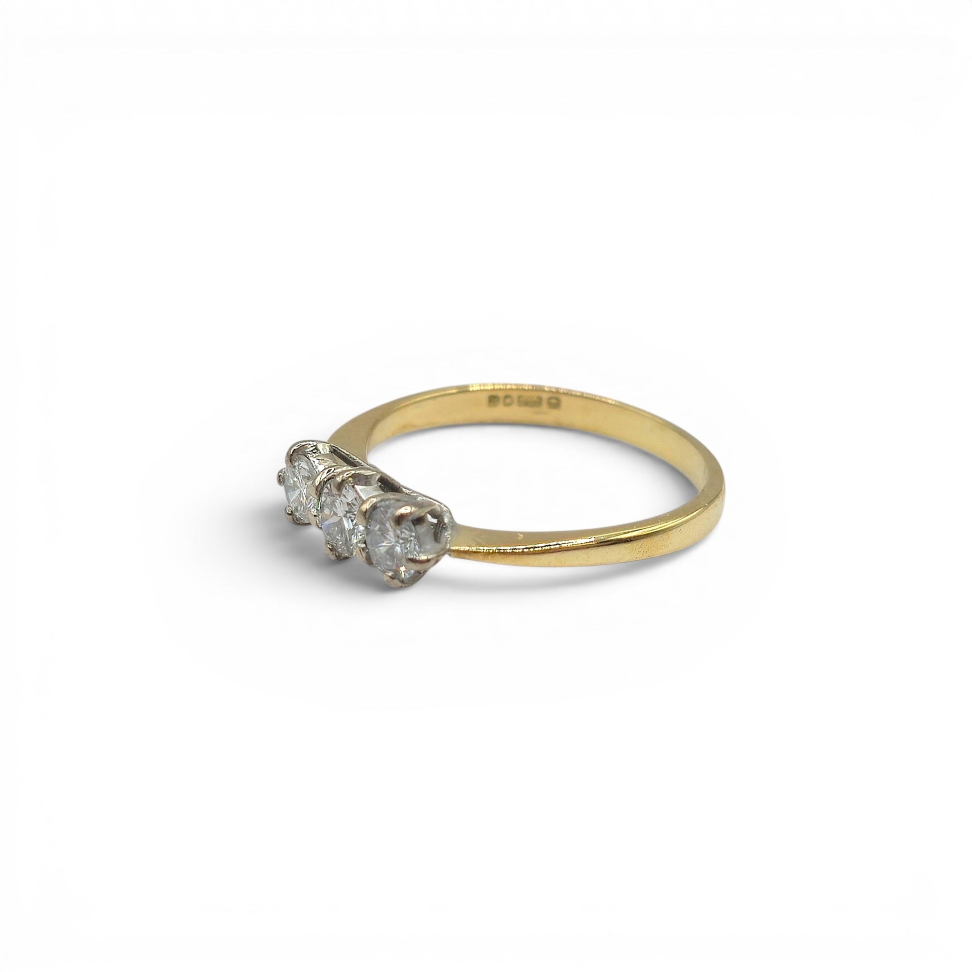18ct yellow gold three-stone diamond ring by Reeves and Sons, showcasing sparkling diamonds and elegant craftsmanship.