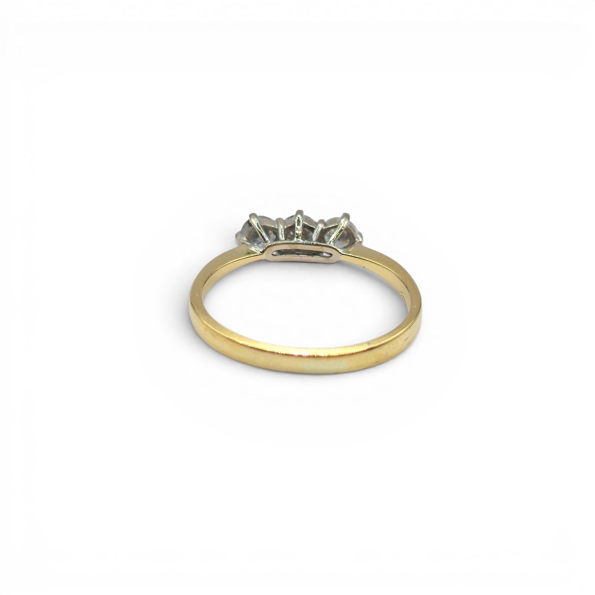 18ct yellow gold three-stone diamond ring by Reeves and Sons, showcasing a elegant design with sparkling diamonds.