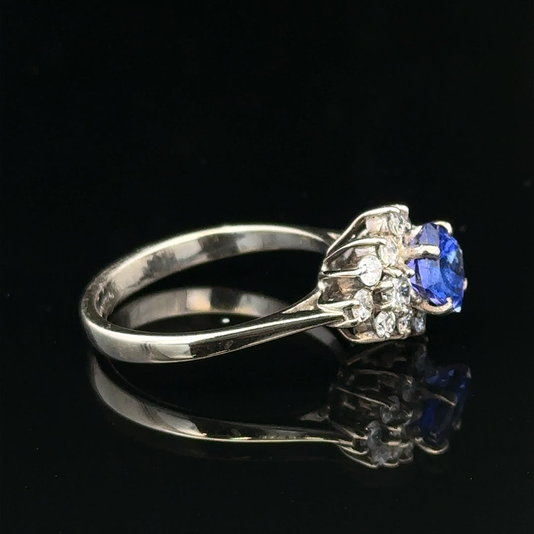 18ct white gold diamond and tanzanite ring, size O, featuring a sparkling central tanzanite gemstone and intricate gold band detail.