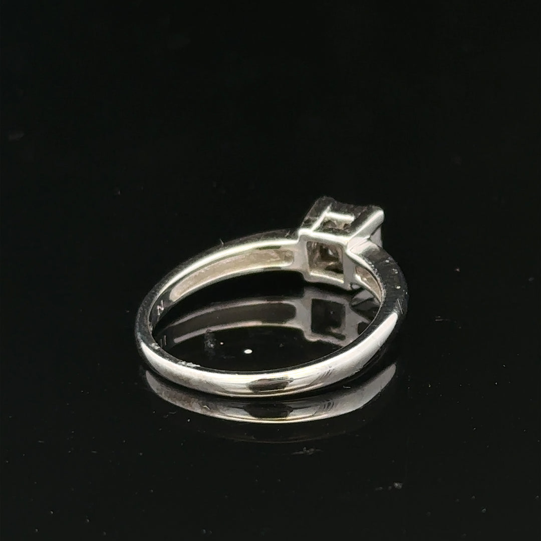 18ct white gold diamond ring with a central diamond, size J1/2, elegant jewelry piece with sparkling stones.