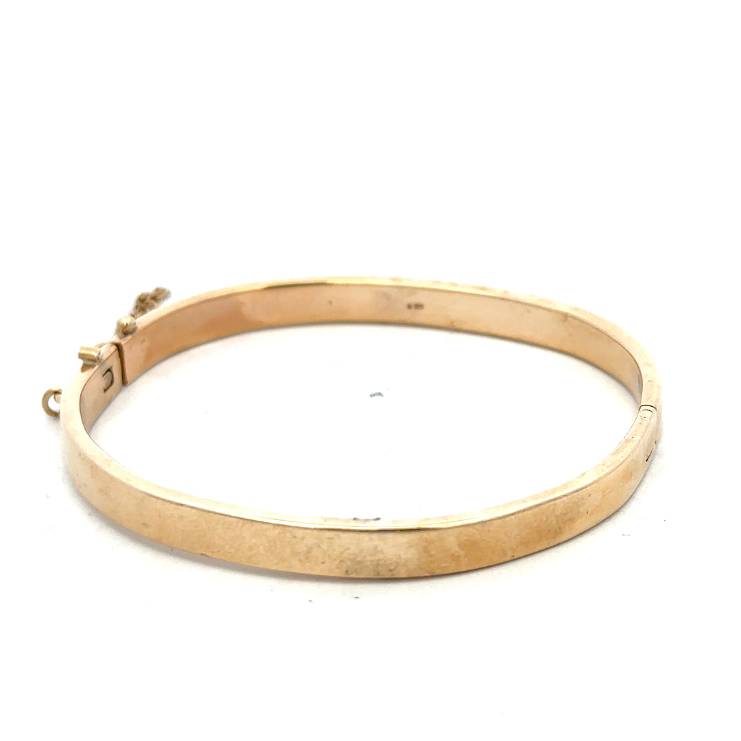 9ct yellow gold bangle bracelet with a smooth polished finish, weighing 24.1 grams, by Reeves and Sons.