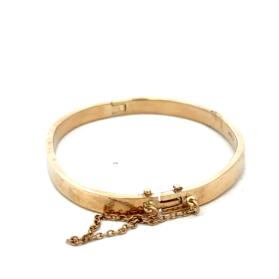 9ct yellow gold bracelet by Reeves and Sons, 24.1g, featuring a smooth, polished bangle design with a shiny finish.