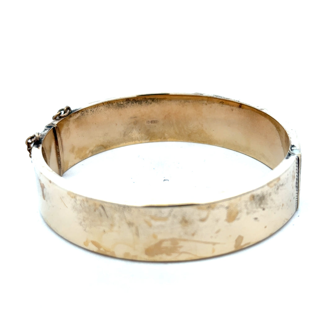 9ct yellow gold bangle bracelet from Reeves and Sons, showcasing a polished, rounded design with a secure clasp.