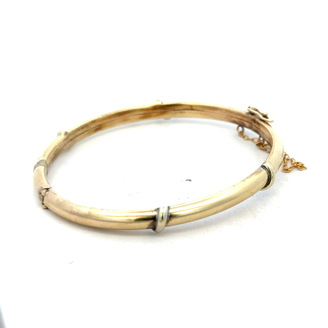 9ct yellow gold bangle bracelet weighing 11.1g, from Reeves and Sons, with a smooth, polished finish.