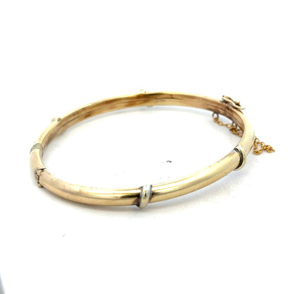 9ct yellow gold bangle bracelet weighing 11.1g, from Reeves and Sons, with a smooth, polished finish.