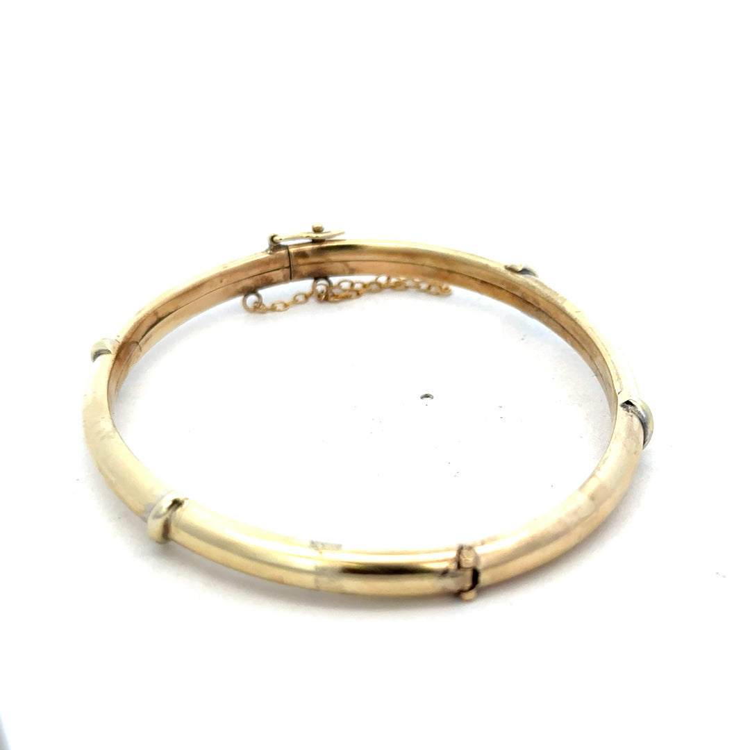 9ct yellow gold bracelet by Reeves and Sons, stylish bangle weighing 11.1g, with a smooth polished finish and elegant design.