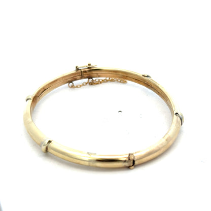 9ct yellow gold bracelet by Reeves and Sons, stylish bangle weighing 11.1g, with a smooth polished finish and elegant design.