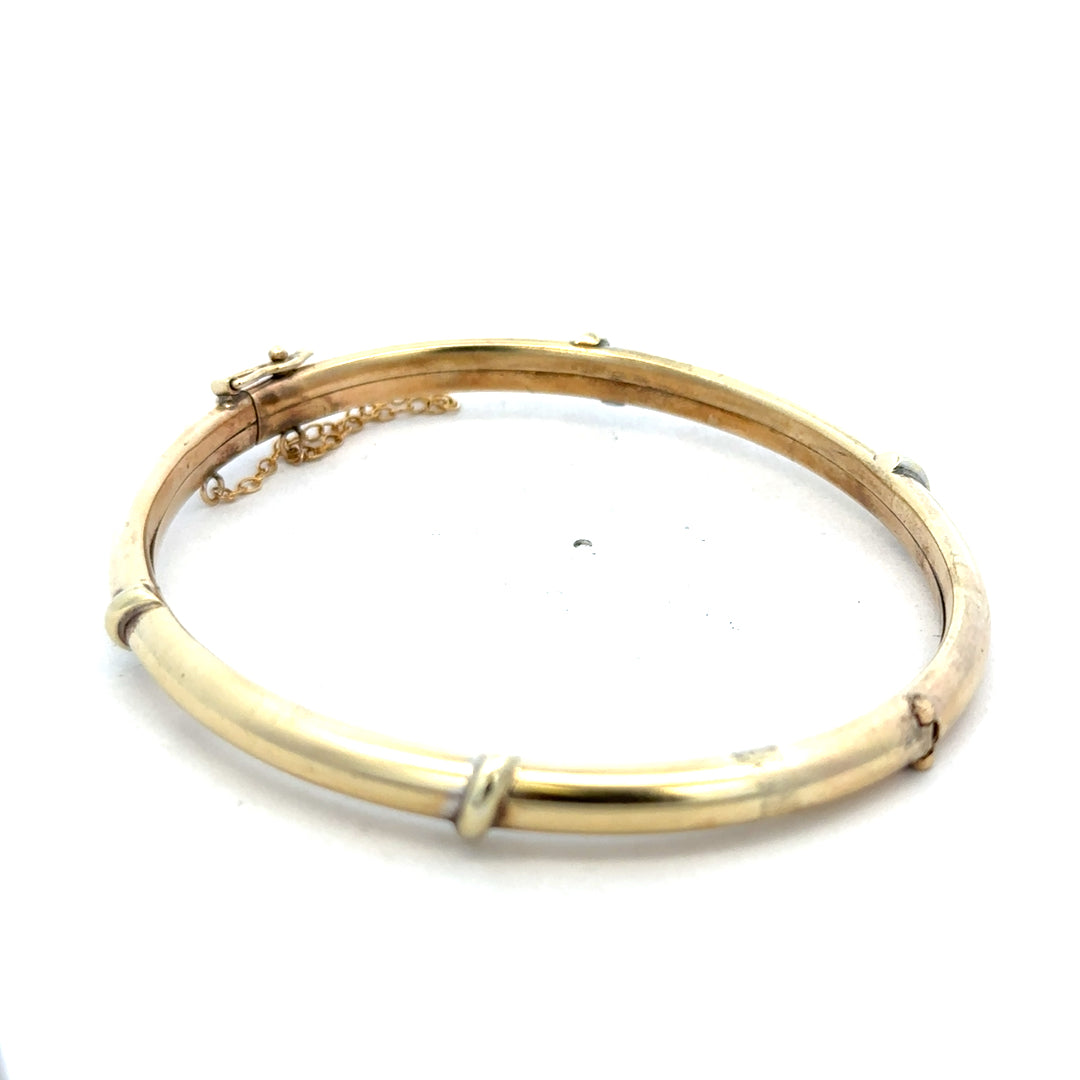 9ct yellow gold bangle bracelet with a smooth finish, weighing 11.1g, from Reeves and Sons.