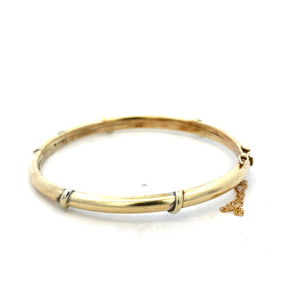 9ct yellow gold bangle bracelet by Reeves and Sons, 11.1g, with a smooth polished finish and classic design.
