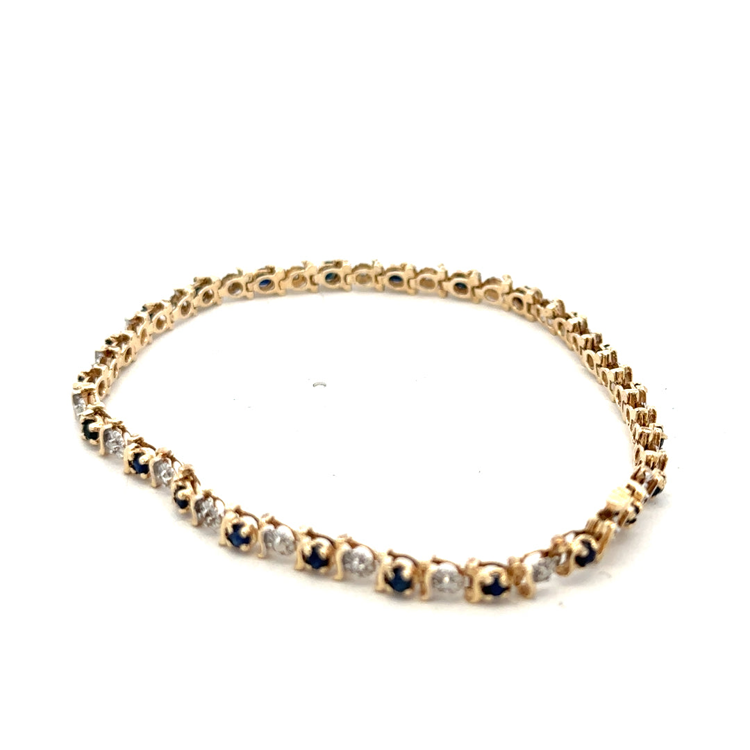 9ct yellow gold sapphire and diamond bracelet from Reeves and Sons, featuring a delicate design and sparkling gemstones.