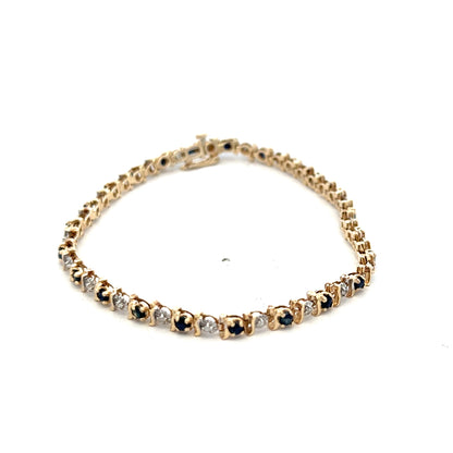 Reeves and Sons 9ct yellow gold bracelet with sapphires and diamonds, showcasing a delicate, elegant jewelry design.