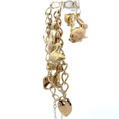 9ct yellow gold charm bracelet from Reeves and Sons, showcasing a delicate chain with small decorative charms and a secure clasp.