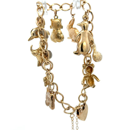 Reeves and Sons 9ct yellow gold charm bracelet, 13.4g, featuring intricate charms and polished finish on a delicate chain
