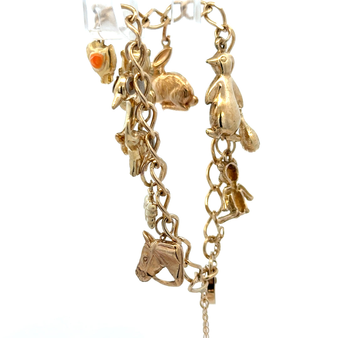 Reeves and Sons 9ct yellow gold charm bracelet with intricate links and a secure clasp, weighing 13.4g.