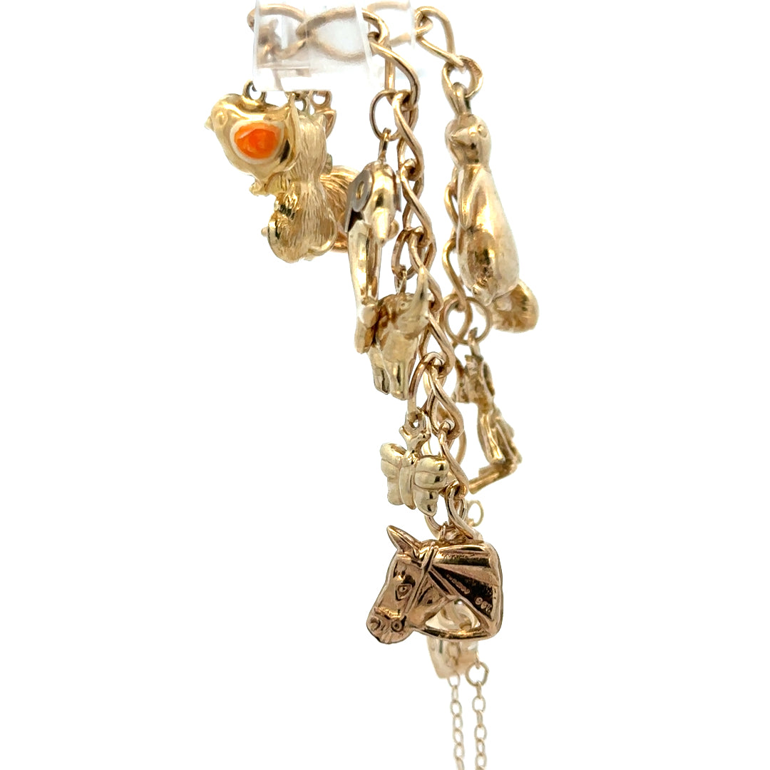 9ct yellow gold charm bracelet from Reeves and Sons with intricate detailing and a secure clasp, weighing 13.4g.