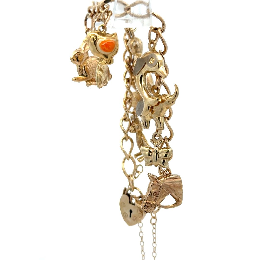 9ct yellow gold charm bracelet with intricate links, weighing 13.4g, featuring detailed decorative charms and a secure clasp.