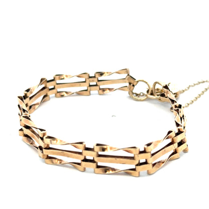 9ct yellow gold gate bracelet by Reeves and Sons, showcasing polished interlocking links on a white background.