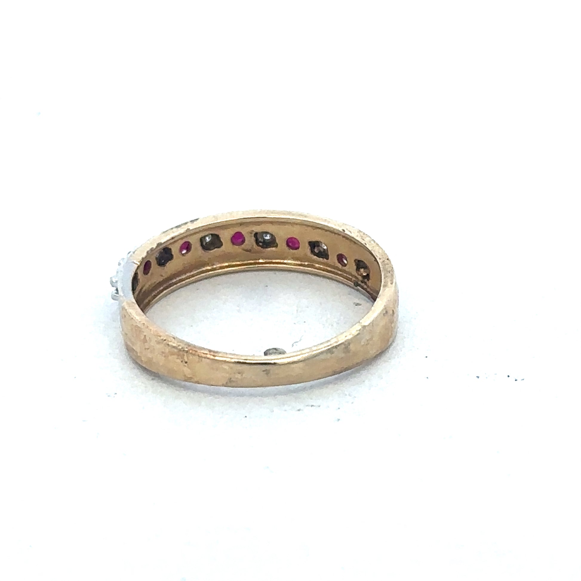 9ct yellow gold ruby and diamond ring by Reeves and Sons, featuring a central ruby surrounded by sparkling diamonds.