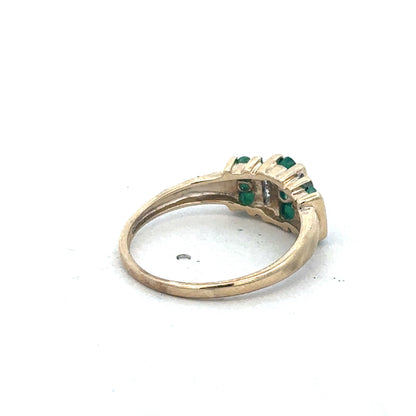 9ct yellow gold emerald and diamond ring by Reeves and Sons with a central emerald gemstone and diamond accents.