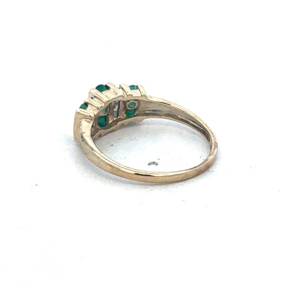 9ct yellow gold emerald and diamond ring by Reeves and Sons, featuring a central emerald gemstone and sparkling diamonds.