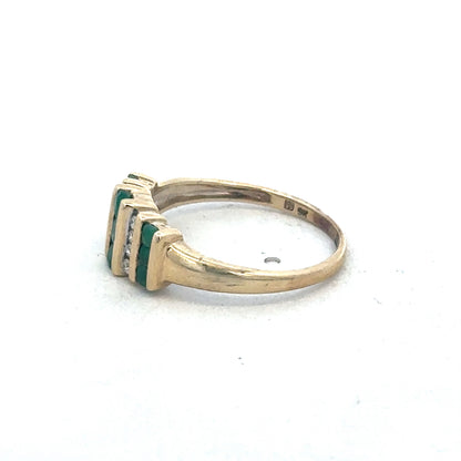 9ct yellow gold emerald and diamond ring by Reeves and Sons, showcasing a vibrant emerald center stone with sparkling diamonds.
