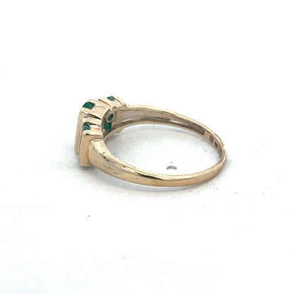 9ct yellow gold emerald and diamond ring by Reeves and Sons, showcasing a central emerald gemstone with diamond accents.