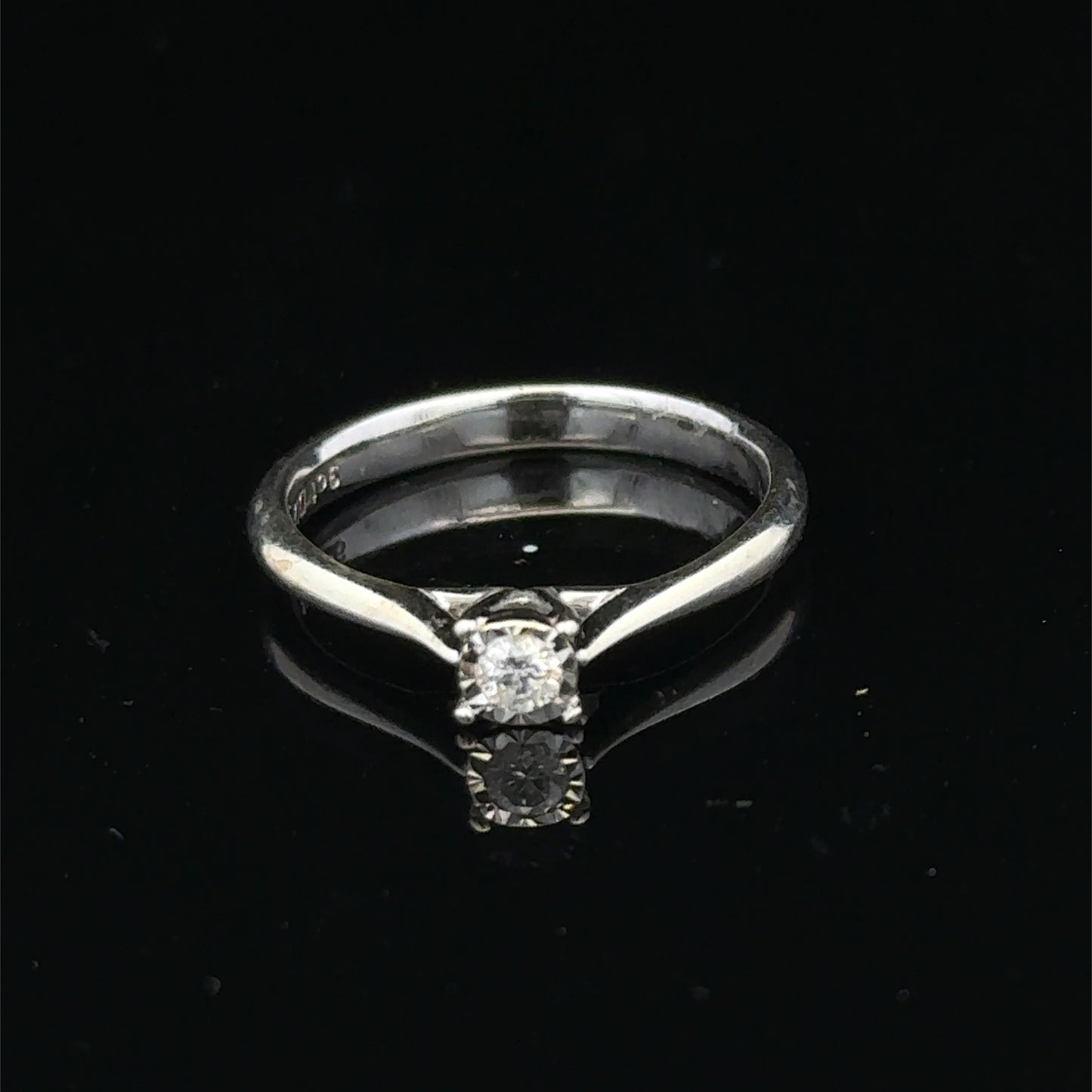9ct white gold diamond solitaire ring by Reeves and Sons with a prominent central diamond and sleek band design.
