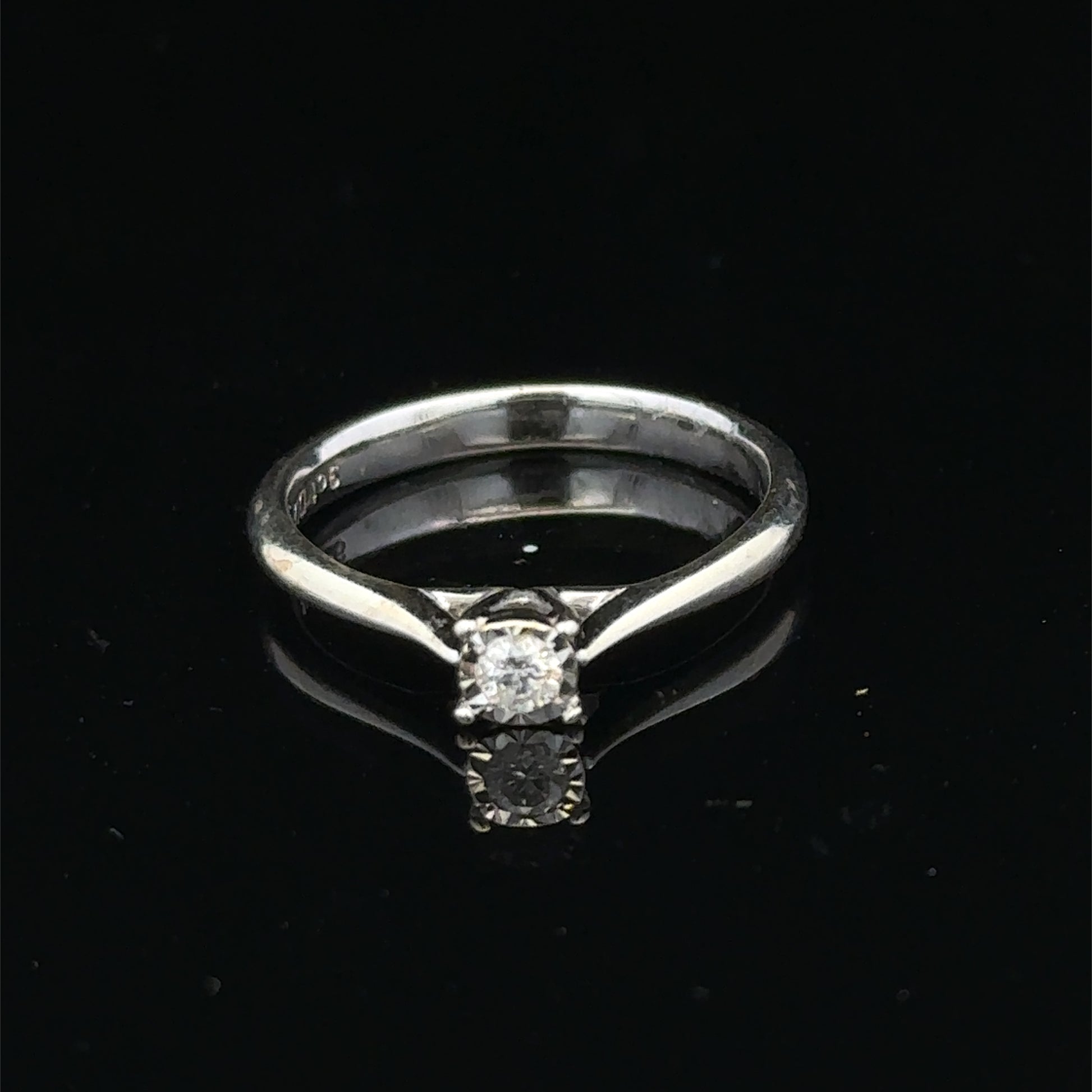 9ct white gold diamond solitaire ring by Reeves and Sons with a prominent central diamond and sleek band design.