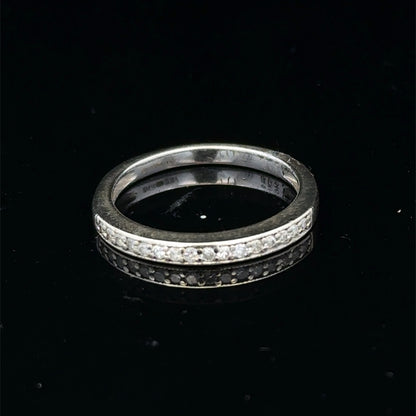 9ct white gold diamond half eternity ring with sparkling diamonds, crafted by Reeves and Sons, shown from a side angle.