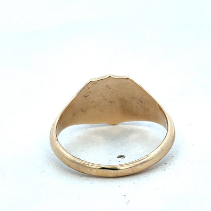9ct yellow gold signet ring in size T by Reeves and Sons, showing the polished gold surface and classic design.