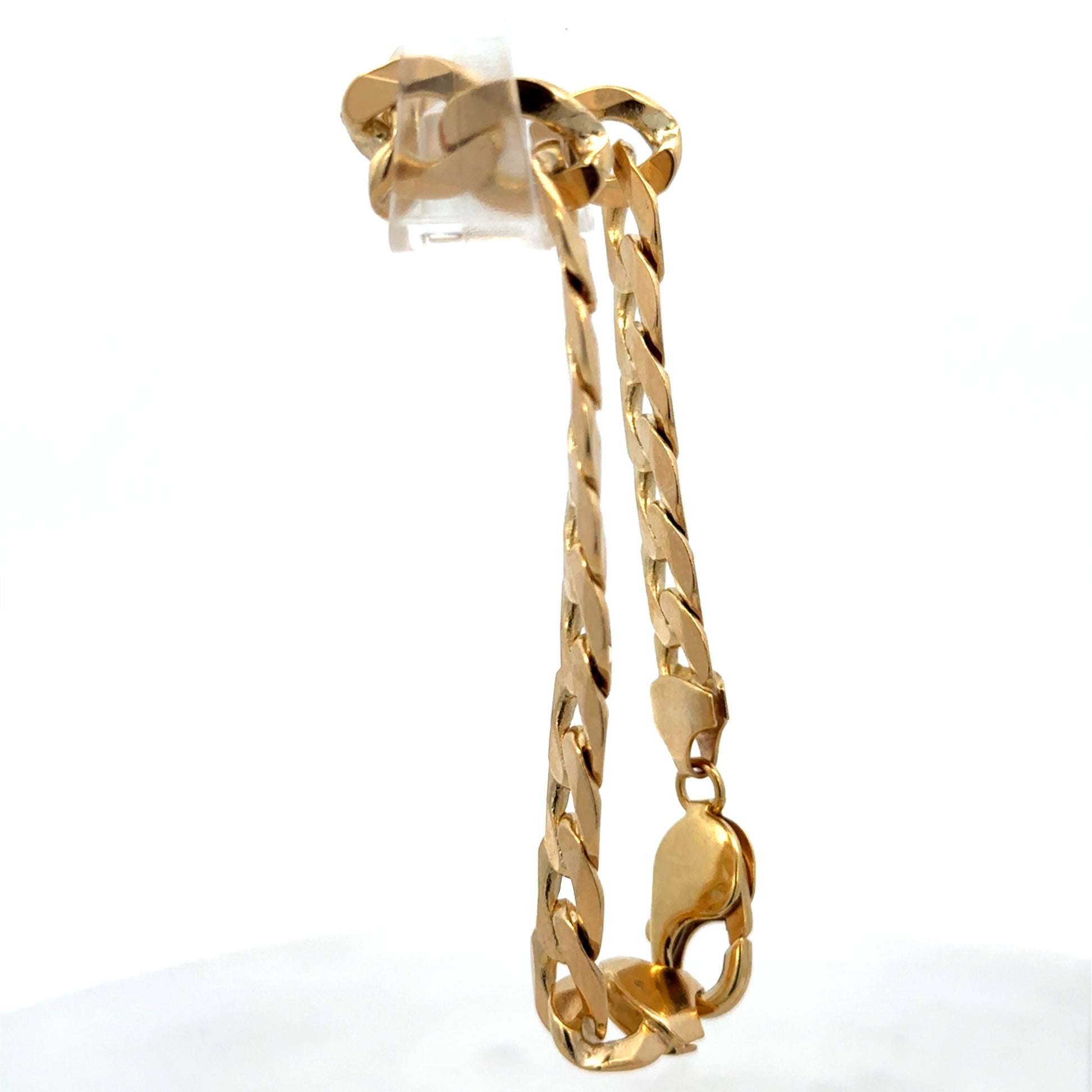 9ct yellow gold curb bracelet weighing 29.9g with a polished finish, crafted by Reeves and Sons.
