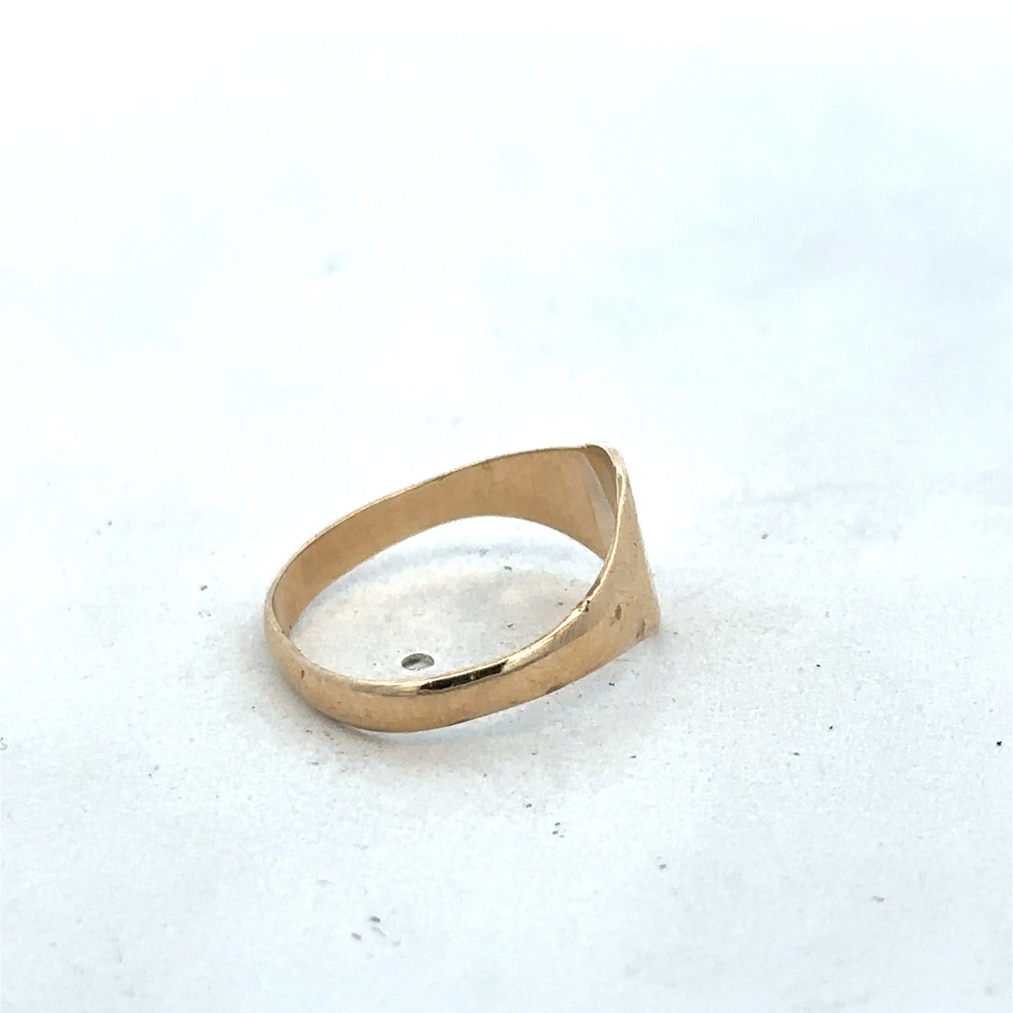 9ct yellow gold signet ring in size M by Reeves and Sons, close-up showing polished surface and classic design.