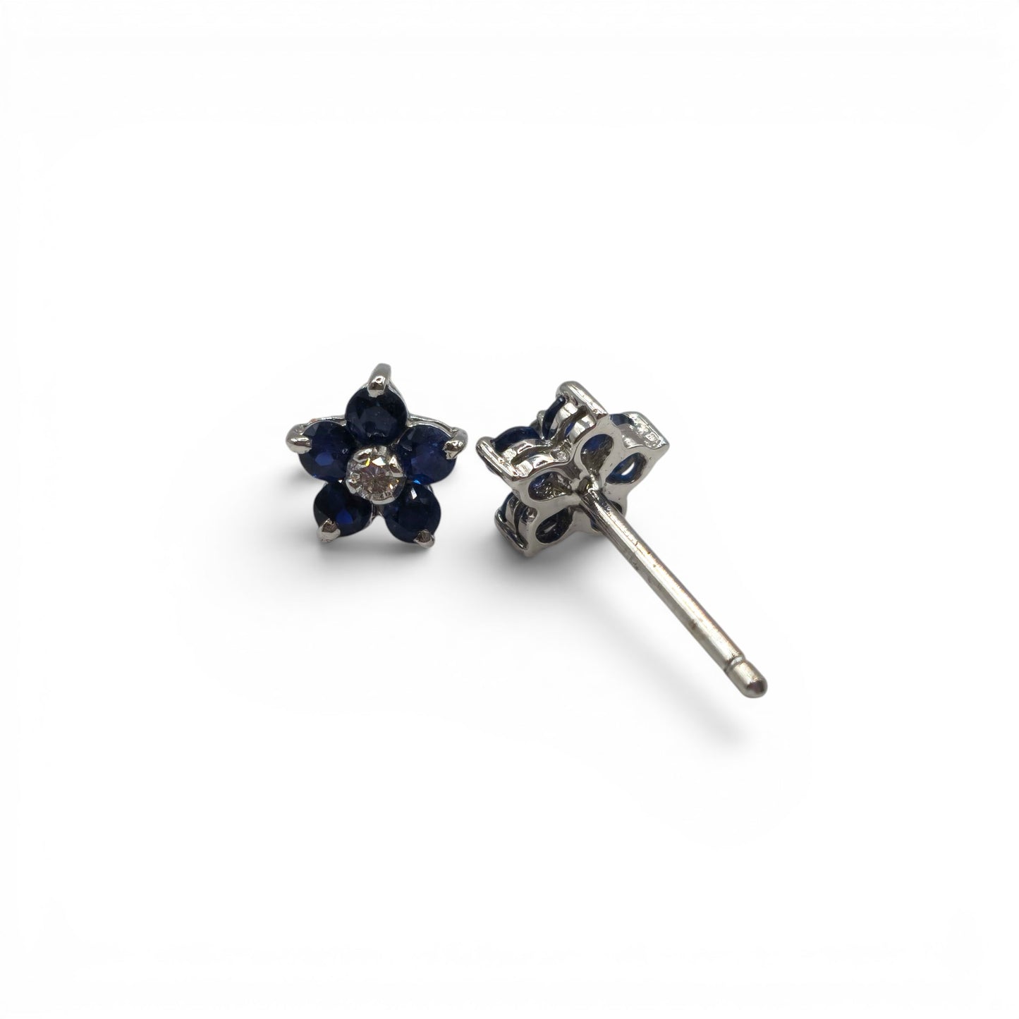 18ct white gold daisy sapphire and diamond stud earrings by Reeves and Sons, featuring floral design with blue sapphires and sparkling diamonds.