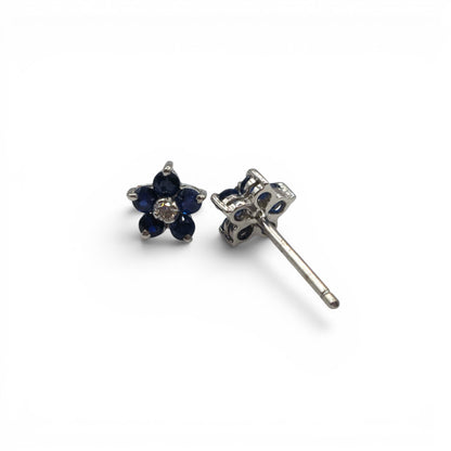 18ct white gold daisy sapphire and diamond stud earrings by Reeves and Sons, featuring floral design with blue sapphires and sparkling diamonds.