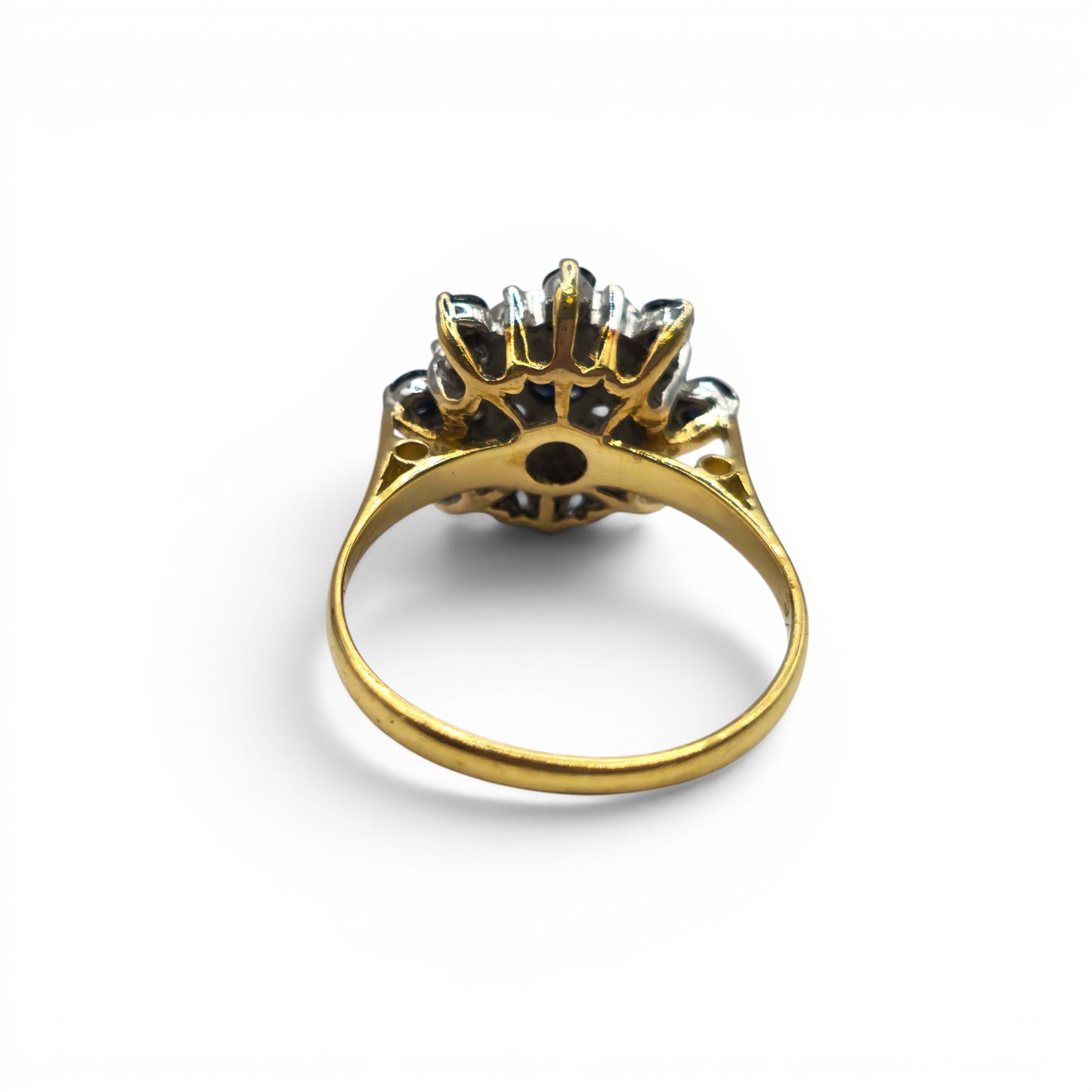 18ct yellow gold sapphire and diamond cluster ring by Reeves and Sons, featuring a vibrant sapphire center and sparkling diamonds.