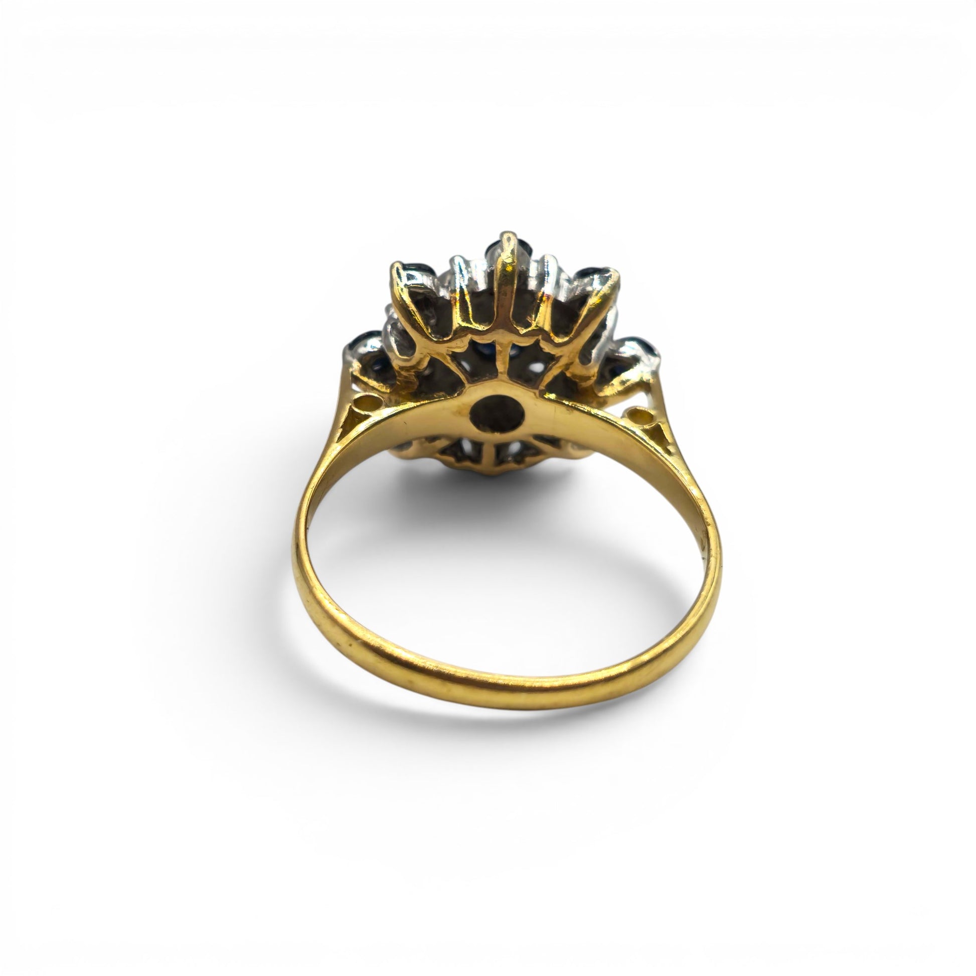 18ct yellow gold sapphire and diamond cluster ring by Reeves and Sons, featuring a vibrant sapphire center and sparkling diamonds.