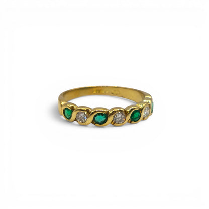 18ct yellow gold half eternity ring with emeralds and diamonds, featuring intricate gemstone settings and Reeves and Sons craftsmanship.