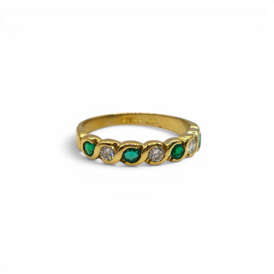 18ct yellow gold half eternity ring with emeralds and diamonds, featuring intricate gemstone settings and Reeves and Sons craftsmanship.