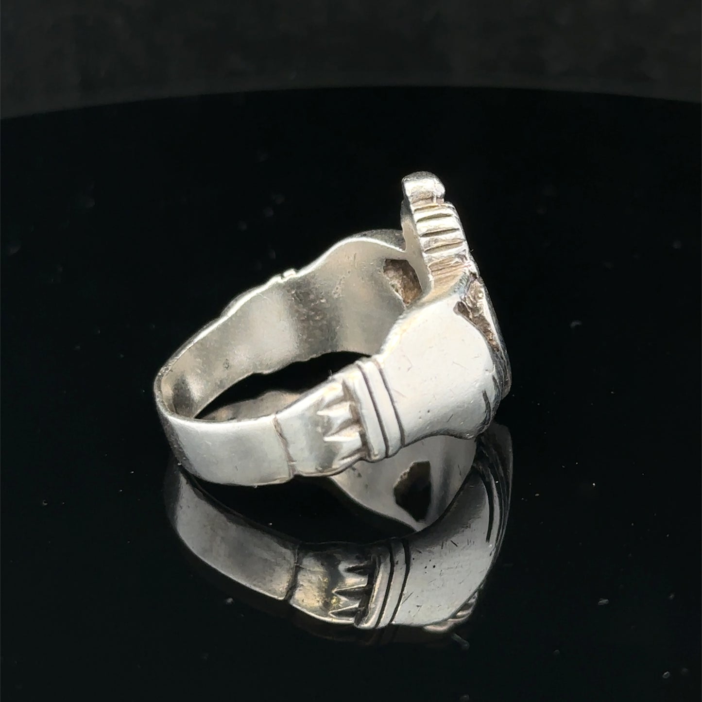 Silver Claddagh ring in size Z1 by Reeves and Sons, featuring a detailed heart and crown design, resting on a neutral background.