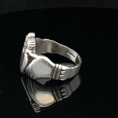 Silver Claddagh ring size Z1 by Reeves and Sons, featuring a detailed heart and crown design, close-up view.