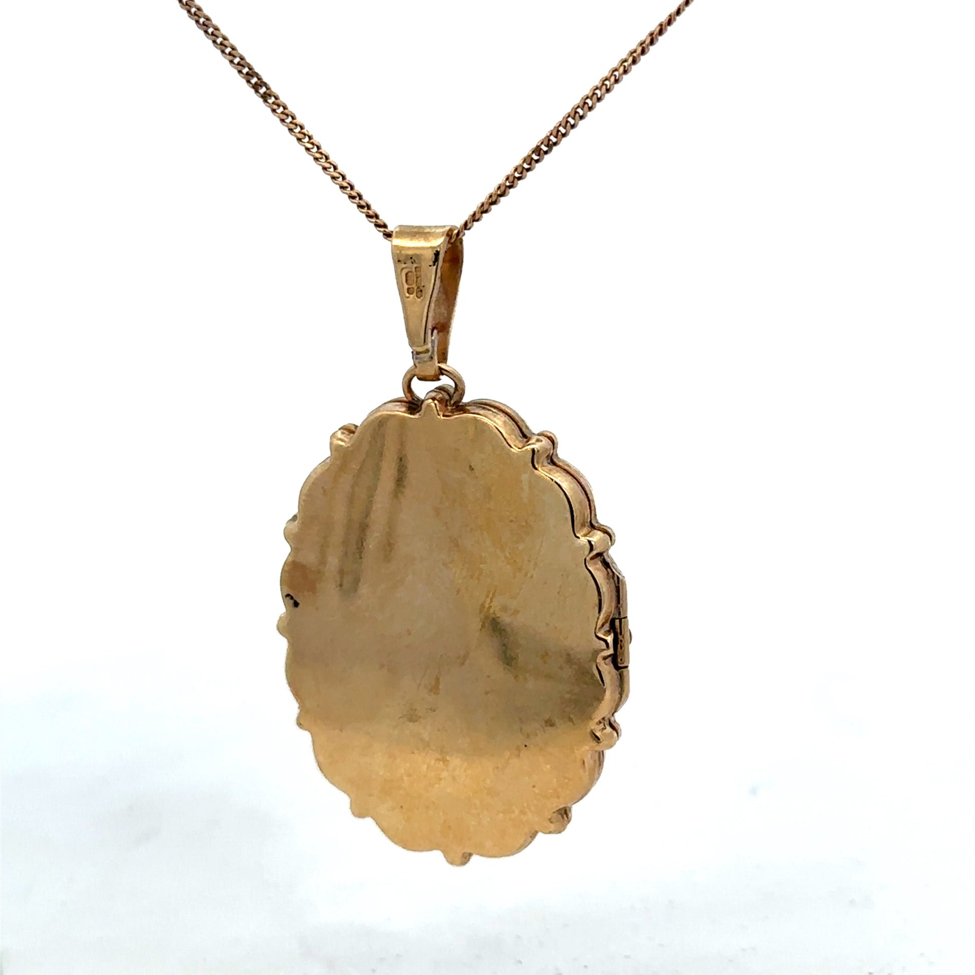 9ct yellow gold locket pendant with intricate design, weighing 8.1g, by Reeves and Sons, shown in close-up view.