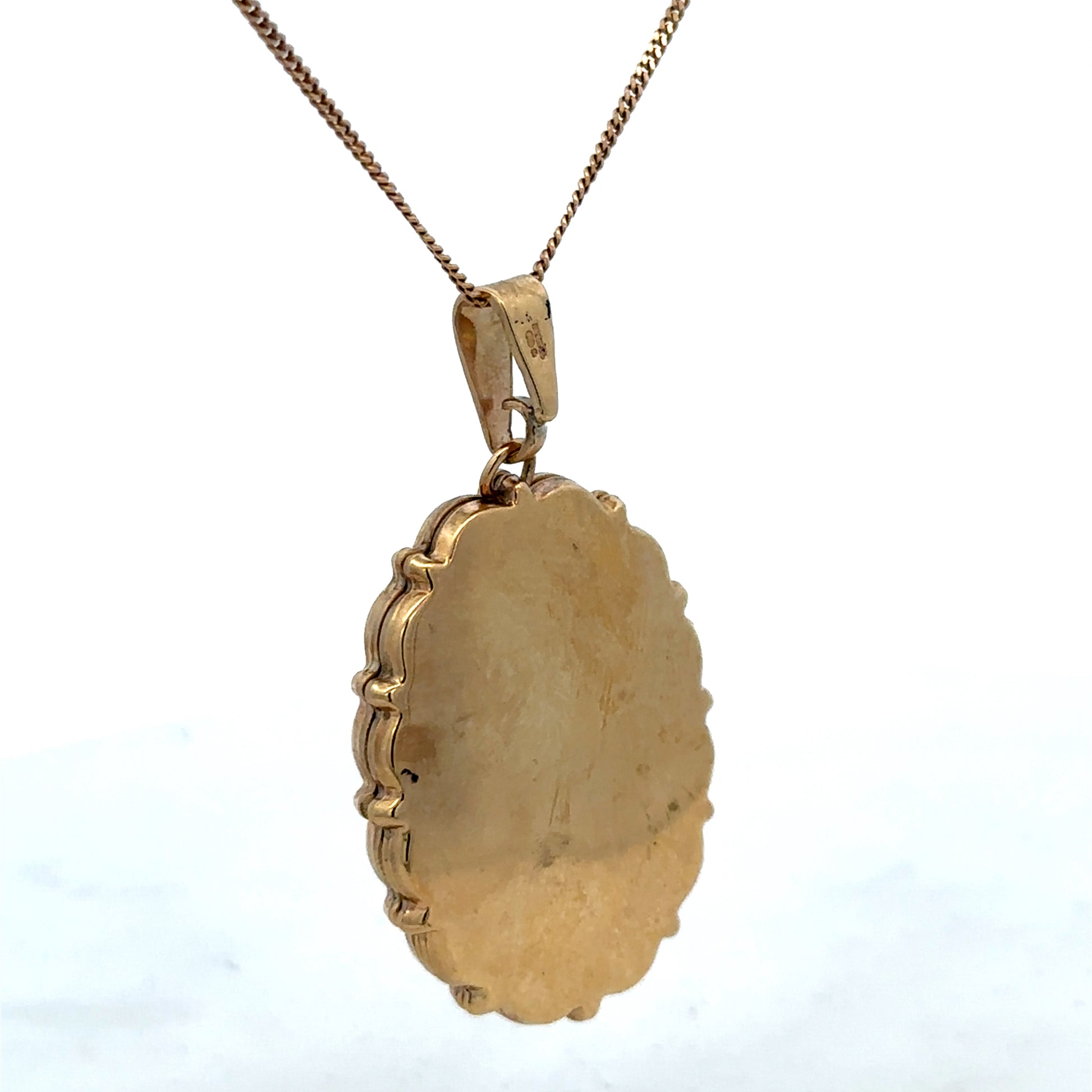9ct yellow gold locket pendant by Reeves and Sons, showcasing a polished, oval-shaped jewelry piece with intricate detailing.