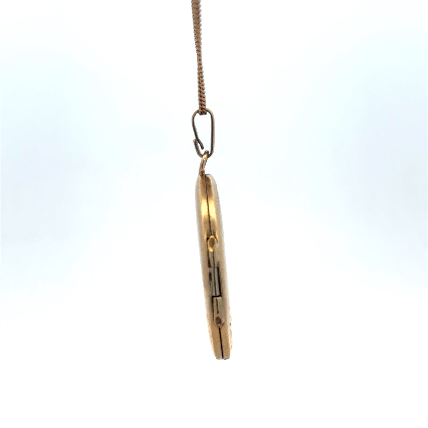 9ct yellow gold locket pendant with floral engraving, Reeves and Sons, weighing 5.4g, close-up view showing detailed craftsmanship.